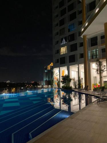 un edificio con piscina por la noche en Putrajaya AQ Homestay (Near PICC) en Putrajaya