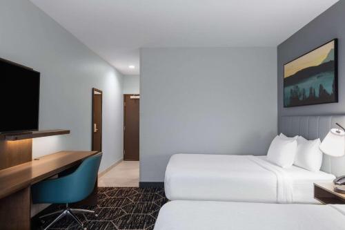 a hotel room with two beds and a desk at La Quinta Inn & Suites by Wyndham Centralia in Centralia