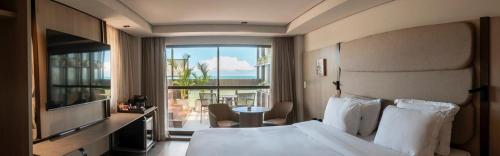 a hotel room with a bed and a view of the ocean at HCM - Hotel Corais de Manaira in João Pessoa