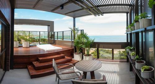 a balcony with a table and chairs and the ocean at HCM - Hotel Corais de Manaira in João Pessoa
