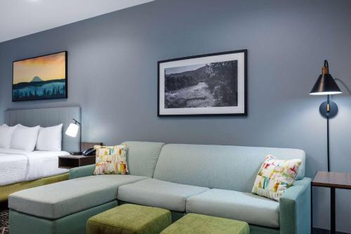 a living room with a couch and a bed at La Quinta Inn & Suites by Wyndham Centralia in Centralia