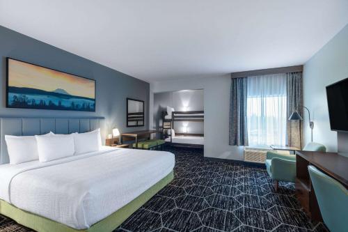 um quarto de hotel com uma cama grande e uma secretária em La Quinta Inn & Suites by Wyndham Centralia em Centralia