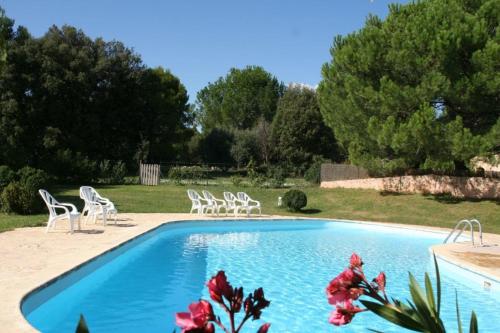- une piscine avec des chaises blanches et des arbres dans l'établissement Lou Penequet a charming Mas in Provence with shared pool countryside, à Flayosc