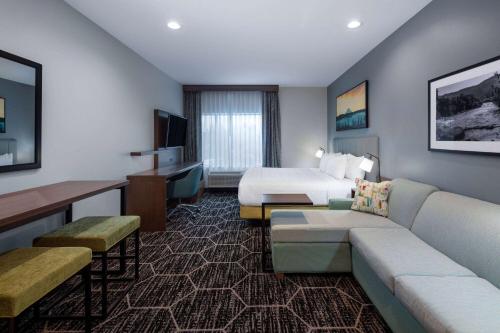 a hotel room with a bed and a couch at La Quinta Inn & Suites by Wyndham Centralia in Centralia