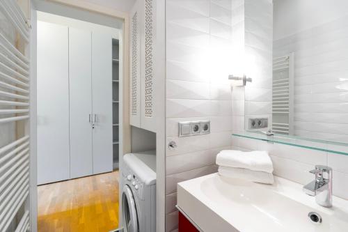 uma casa de banho branca com um lavatório e uma máquina de lavar roupa em Luxury Apartment with Spacious Livingroom at Opera House em Budapeste