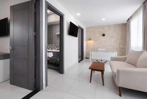 a living room with a couch and a table at Gran Hotel Europa Santo Domingo Trademark Collection by Wyndham in Santo Domingo