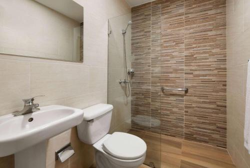 a bathroom with a toilet and a sink and a shower at Gran Hotel Europa Santo Domingo Trademark Collection by Wyndham in Santo Domingo