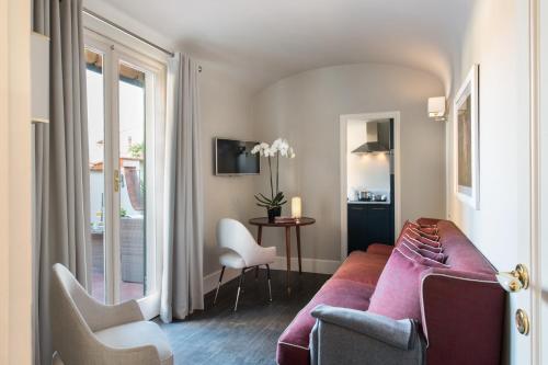 a living room with a couch and a table at Tornabuoni Suites Collection Residenza D'Epoca in Florence