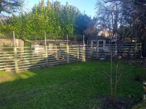 a wooden fence in a yard next to a field at House - Sleeps 2 pet friendly & free parking in Hull