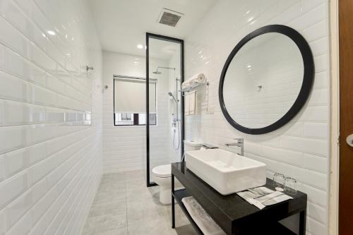 ein weißes Badezimmer mit einem Waschbecken und einem Spiegel in der Unterkunft SGI Vacation Club Villa @ Damai Laut Holiday Resort in Lumut