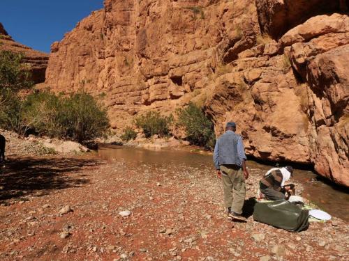 a group of people walking along a river in a canyon at Dar Essalama Dades in Akhendachou nʼAït Ouffi