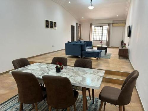 a living room with a table and chairs at Wyndham Villa in Ogbojo