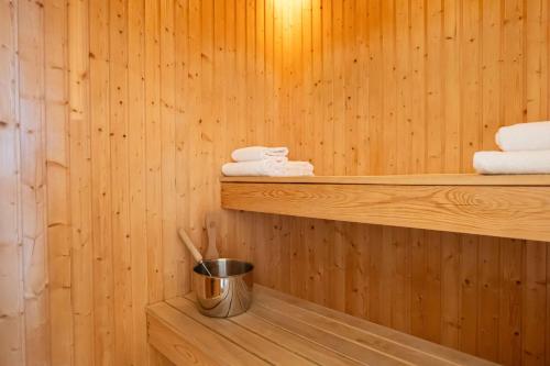 a sauna with towels and a bucket on a shelf at Best Western Plus Park City Solna in Solna