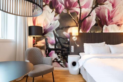 een hotelkamer met een bed en een muurschildering van bloemen bij Best Western Plus Park City Lund in Lund