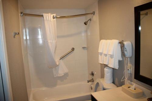 y baño con ducha, bañera y aseo. en Boca Suites Deerfield Beach; SureStay Collection by BW, en Deerfield Beach
