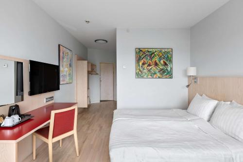 a hotel room with a bed and a desk at Best Western Plus Park City Hammarby Sjöstad in Stockholm