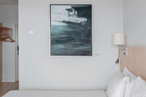 a painting of a car on a wall next to a bed at Best Western Plus Park City Hammarby Sjöstad in Stockholm