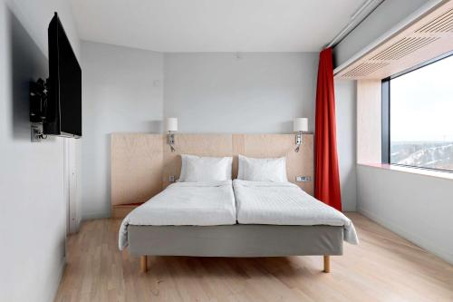 a bedroom with a bed and a large window at Best Western Plus Park City Hammarby Sjöstad in Stockholm