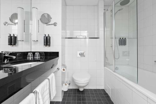 ein weißes Bad mit einem WC und einer Dusche in der Unterkunft Best Western Plus Park City Hammarby Sjöstad in Stockholm