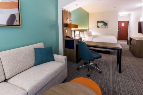 a hotel room with a bed and a desk and a couch at Comfort Inn & Suites New Iberia - Avery Island in New Iberia
