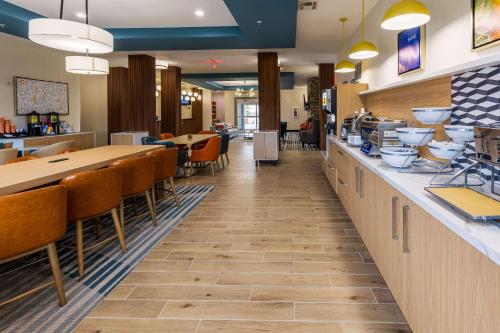 ニューアイビーリアにあるComfort Inn & Suites New Iberia - Avery Islandの長いカウンターとテーブルと椅子が備わるレストラン