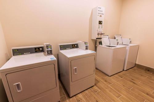 three washers and dryers are lined up in a room at Comfort Inn & Suites New Iberia - Avery Island in New Iberia
