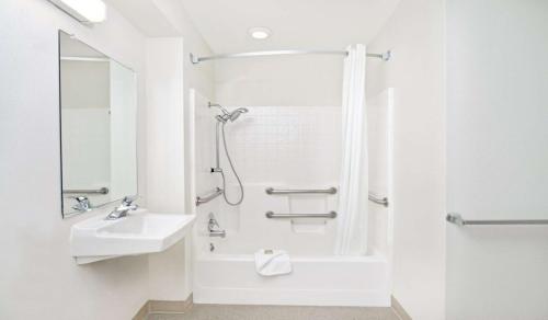 サクラメントにあるスーパー 8 ホテル サクラメント エアポートの白いバスルーム(シャワー、シンク付)