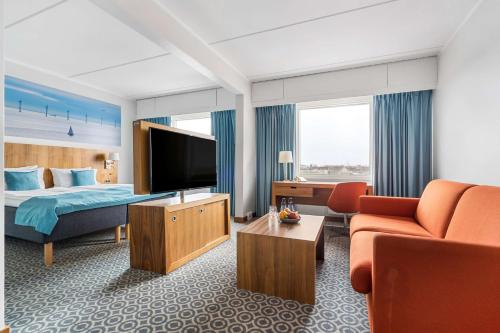 a hotel room with a bed and a flat screen tv at Best Western Plus Park Globetrotter Copenhagen Airport in Copenhagen