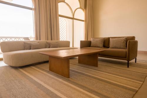 a living room with a couch and a coffee table at Liwa Hotel in Mezairaa