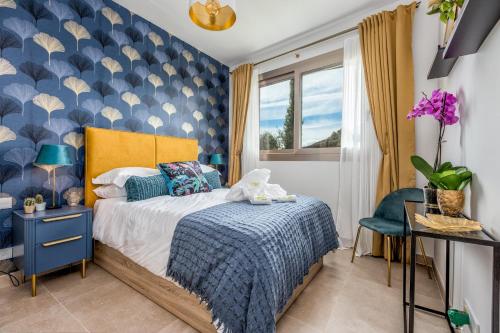 a bedroom with a bed with a blue accent wall at Buena Vista in Mijas Costa