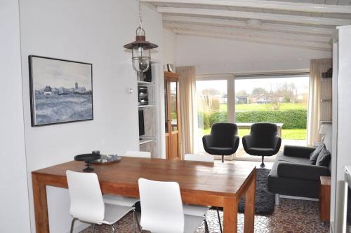 - un salon avec une table et des chaises en bois dans l'établissement De Blenck 7, à Callantsoog