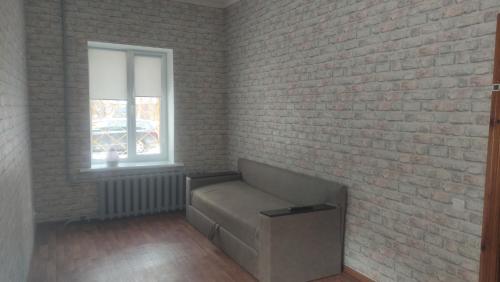 a living room with a couch and a brick wall at Cozy apartment near city center on Peremogy Avenue 44, bus and railway station nearby in Chernihiv