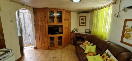 a living room with a couch and a entertainment center at Casa das bonecas in Castro Daire