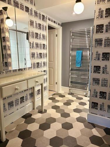 a bathroom with a checkered floor and a large mirror at Summerhill Guest House in Betws-y-coed