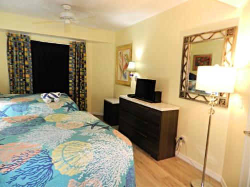sypialnia z łóżkiem, lampką i lustrem w obiekcie 7th Floor 1 BR Resort Condo Direct Oceanfront Wyndham Ocean Walk - Daytona Funland 702 w mieście Daytona Beach