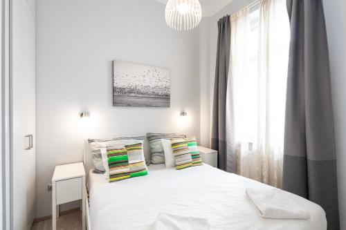 um quarto com uma cama branca e uma janela em Luxury Apartment with Spacious Livingroom at Opera House em Budapeste