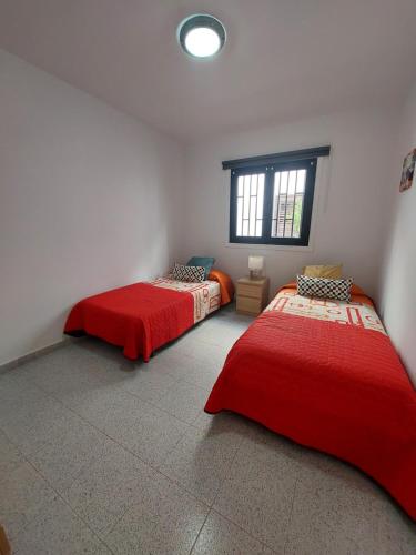 two beds in a room with a window at Agua Marina in Playa Honda