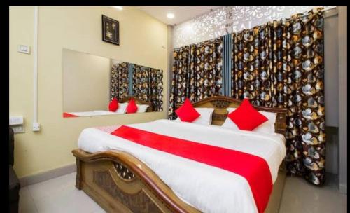a bedroom with a bed with red pillows and a mirror at jai maa in swaraj lodge in Navi Mumbai