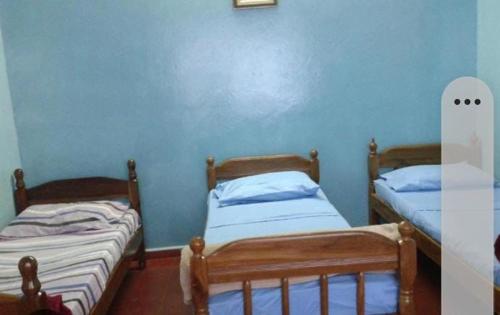 2 łóżka pojedyncze w pokoju z niebieskimi ścianami w obiekcie Hotel Marco w mieście Mar del Plata