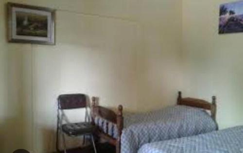 een kamer met 2 bedden en een stoel. bij Hotel Marco in Mar del Plata