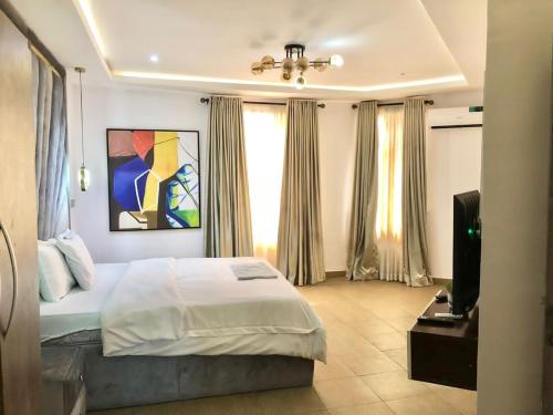 um quarto com uma cama e uma televisão em Three Bedroom Homely Apartment em Lekki