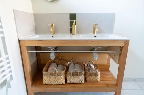 a bathroom vanity with a sink and two pairs of shoes at gîte fleur côte d'opale - Ambleteuse in Ambleteuse