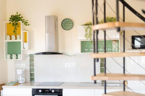 a kitchen with a counter and a clock on the wall at gîte fleur côte d'opale - Ambleteuse in Ambleteuse