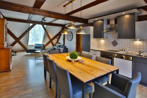 cocina y comedor con mesa de madera y sillas en Ökonomiehof, en Lichtenfels