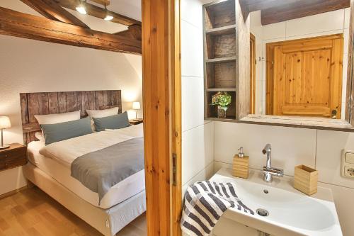 ein Schlafzimmer mit einem Bett und einem Waschbecken in der Unterkunft Ökonomiehof in Lichtenfels