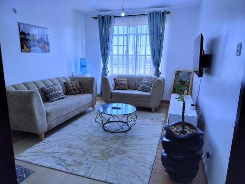 sala de estar con sofá y mesa en FLOZZY HOMES, en Kisumu