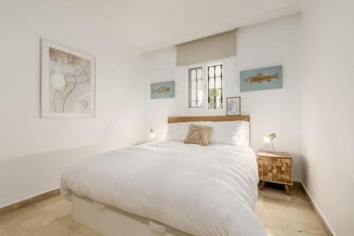 una camera bianca con un grande letto e una finestra di Gorgeous renovated Apt near golf and sea RDR373 a Marbella