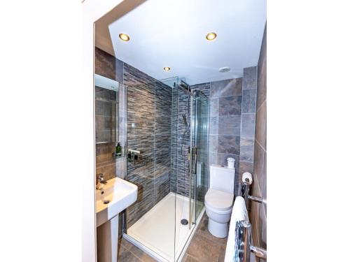 a bathroom with a shower and a toilet and a sink at Pass the Keys Stylish Garden cottage in Wells, Somerset in Wells