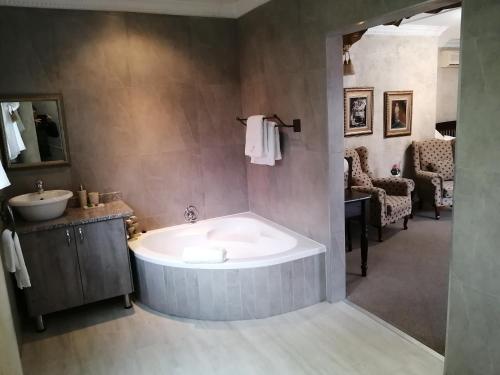 a large bathroom with a tub and a sink at Ancient Emperor Guest Estate in Potchefstroom