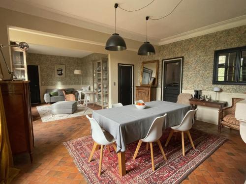 a kitchen and living room with a table and chairs at Suite près de Chambord in Saint Laurent Nouan